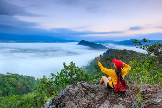 Photo the girl in jacket standing on the mountain