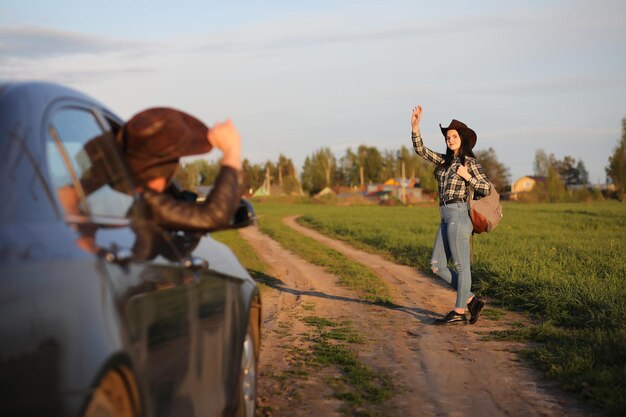 A girl in jeans and a hat travels the summer in the country