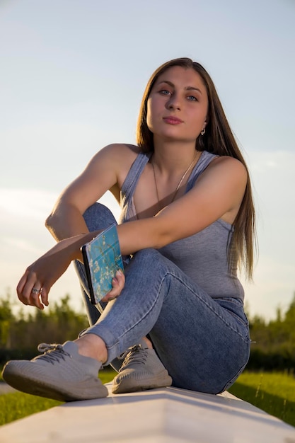 The girl in jeans sits on a tile floor