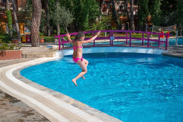 Girl jumping into swimming pool