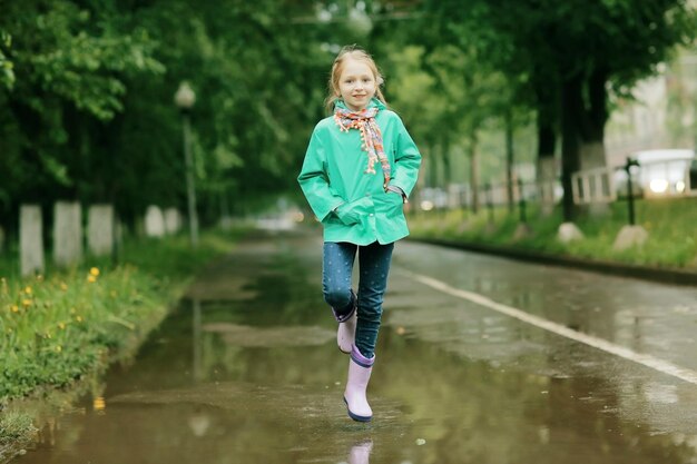 girl jumping in puddles spring rain