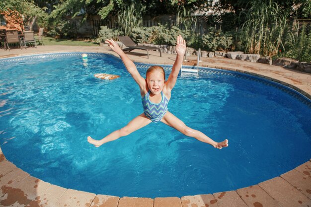 Photo girl jumping in swimming pool