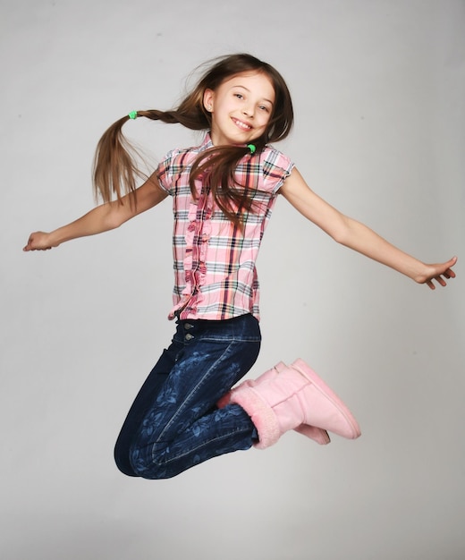 Girl jumps on a gray background