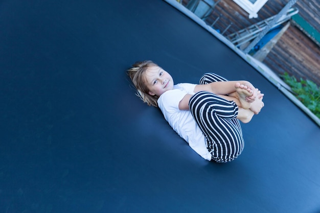 Girl jumps and plays on trampoline