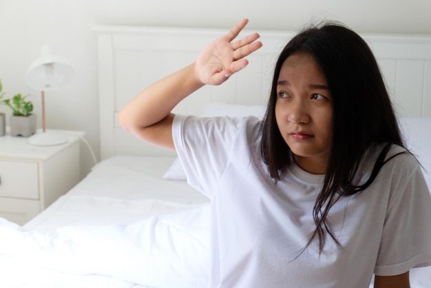 The girl just waking up and sitting on the bed