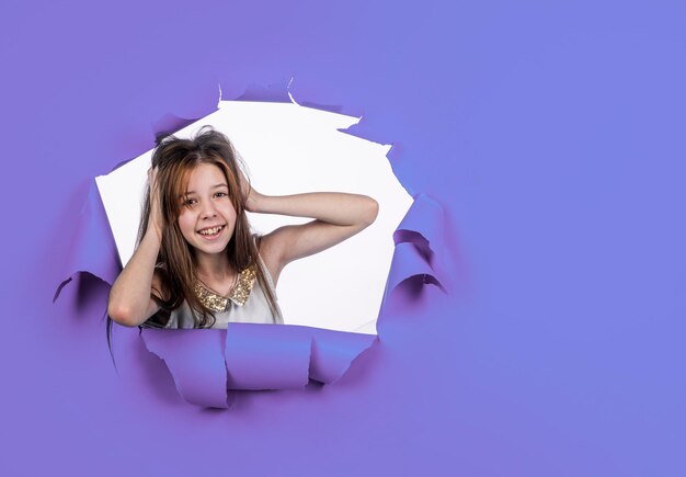 Girl kid touch hair on blue background copy space for ad