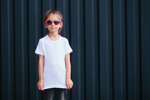 Girl kid wearing white blank  t-shirt with space for your logo or design in casual urban style