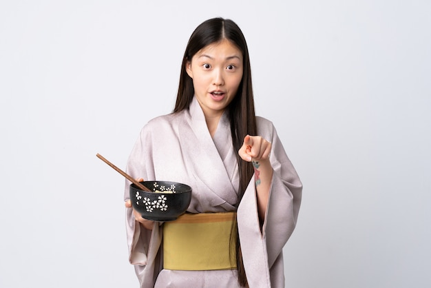 Girl in kimono holding a bowl of noodles