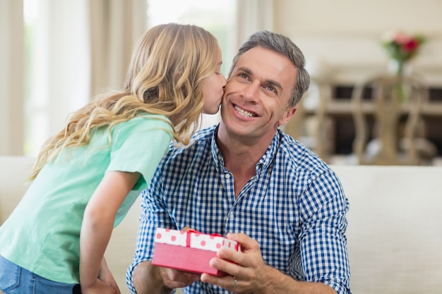 Ragazza che bacia suo padre sulla guancia in salone