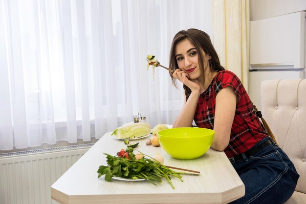 Girl in the kitchen eating a salad of vegetables for a healthy lifestyle