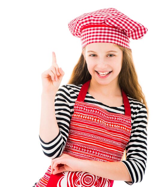 Girl in kitchen upron pointing up