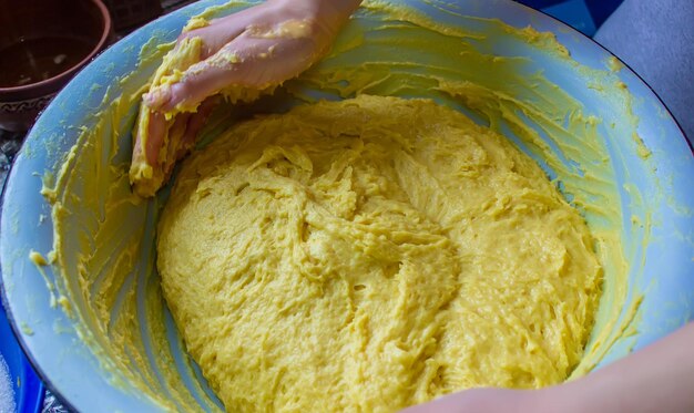 The girl kneads the dough in a bowl