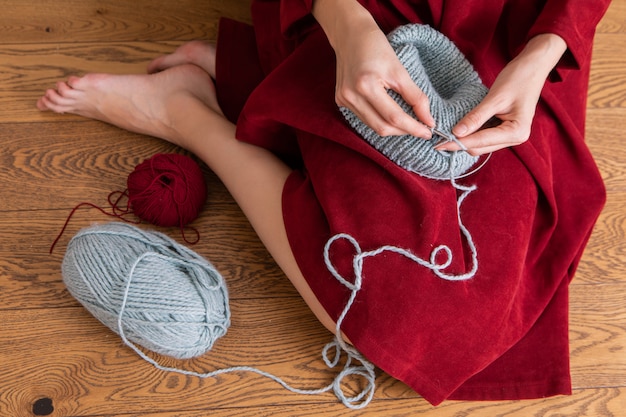 Girl knit gray hat. Sitting at the wooden floor.