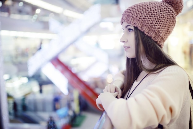 girl in a knitted hat walking in the mall