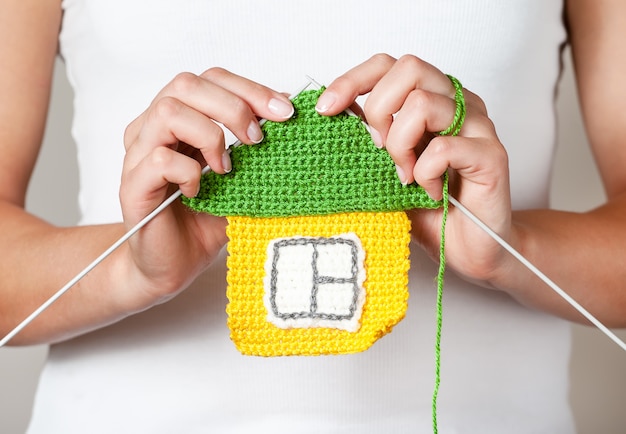 girl knitting a house