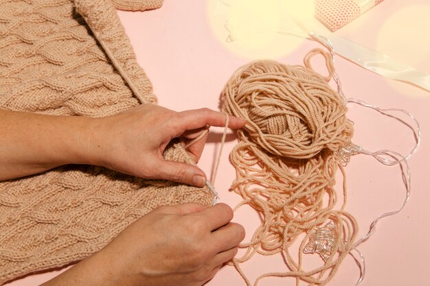 Ragazza che lavora a maglia un maglione caldo vista dall'alto