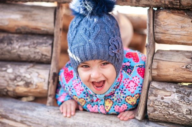 Girl laughing and playing in a wooden house