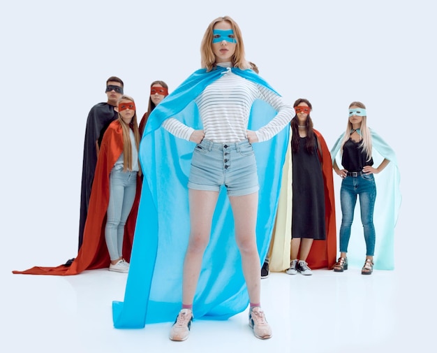 Girl leader in superhero cape standing in front of super\
team