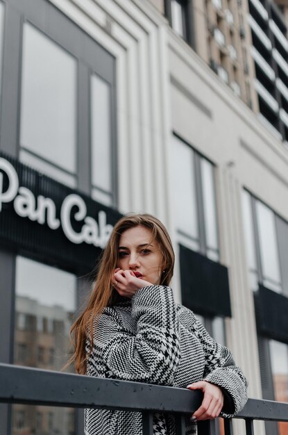 the girl leans on the railing near the building