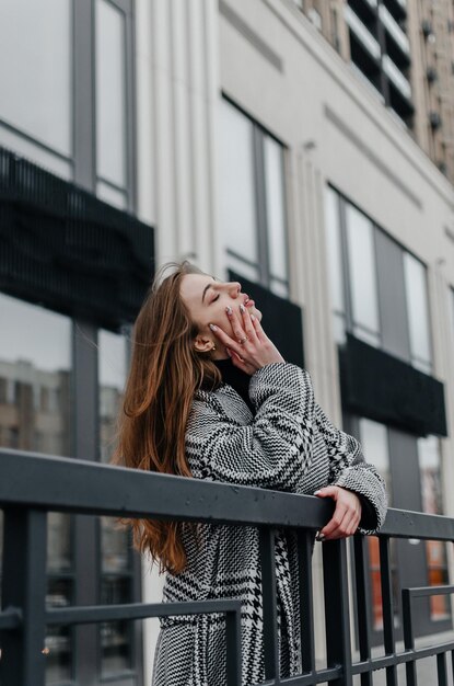 the girl leans on the railing near the building