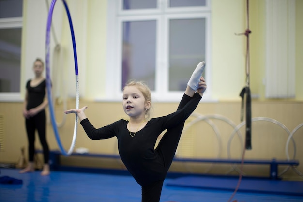 Foto la ragazza impara a torcere il cerchio da ginnastica