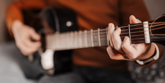 Girl learning to play guitar with the help of online learning at home