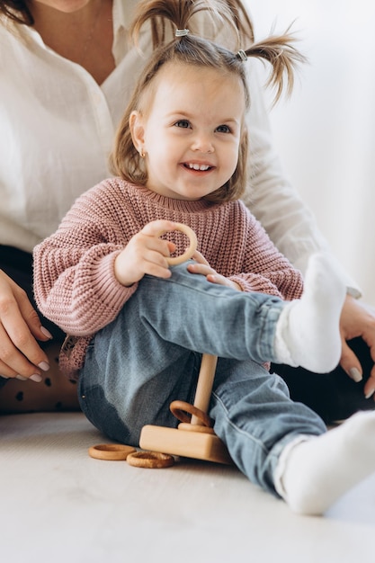 La bambina impara i colori giocando con figure umane colorate di giocattoli cilindrici di legno e mettendole in tazze del colore appropriato il bambino è felice di aver completato correttamente il compito