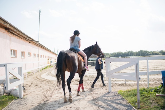 A girl learns to ride a horse