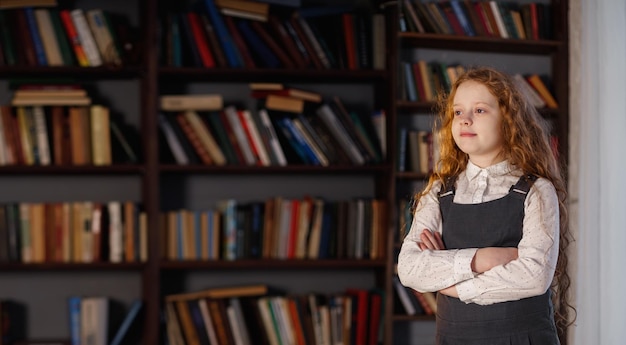 Girl in the library near the shelf with books