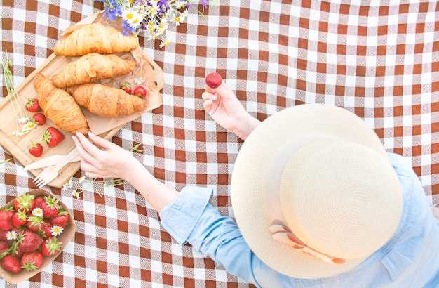 The girl lies on a bedspread in a cage. Summer picnic. Rest. Copy space.