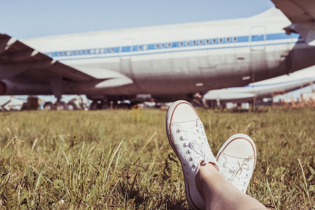 Girl lies on the grass with legs in sneakers