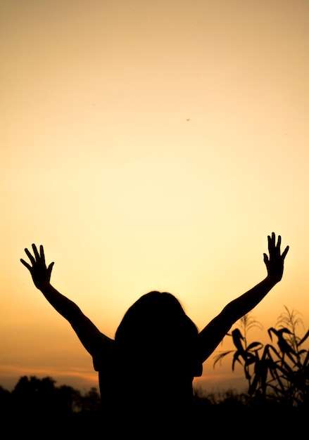 Girl lifting her hands up in the air across the field 