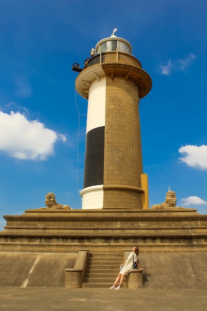 The girl next to the lighthouse in Colombo Sri Lanka Blue sky vertical image