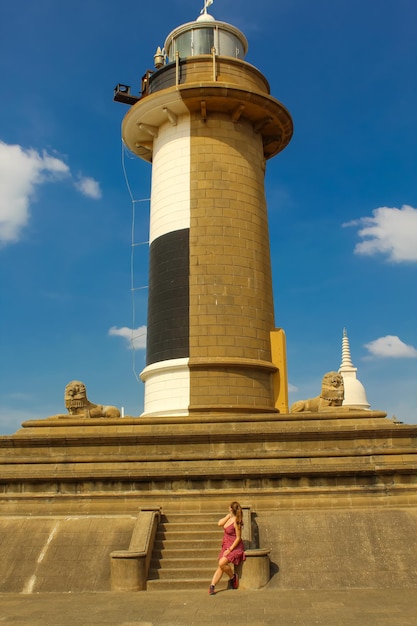 The girl next to the lighthouse in Colombo Sri Lanka Blue sky vertical image