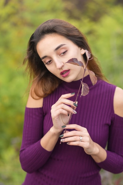 Ragazza in abito lilla sulla natura in autunno ritratto di una bella ragazza in autunno nella foresta