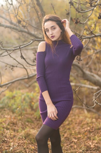 秋の自然に薄紫色のドレスを着た少女、森の中で秋の美しい少女の肖像画