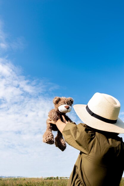 Girl in a linen dress and a straw hat walks wicker basket in hands wellness and freedom concept