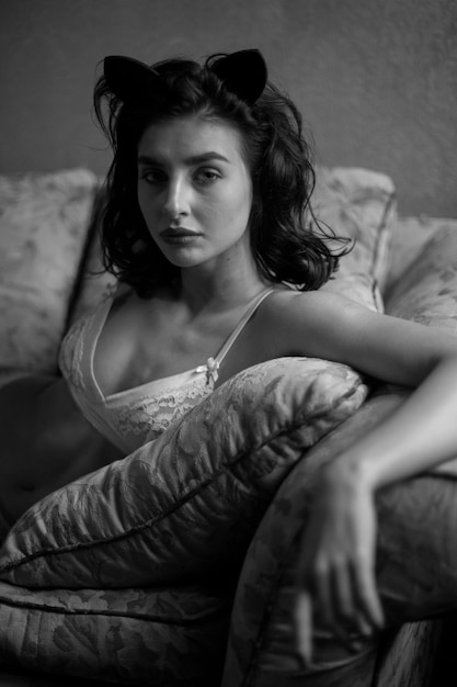 Girl in lingerie and with curly black hair posing in vintage interior black and white photo
