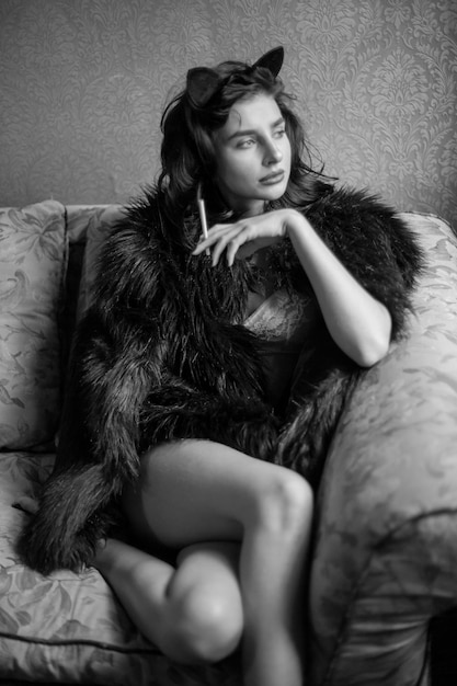 Girl in lingerie and with curly black hair posing in vintage interior black and white photo