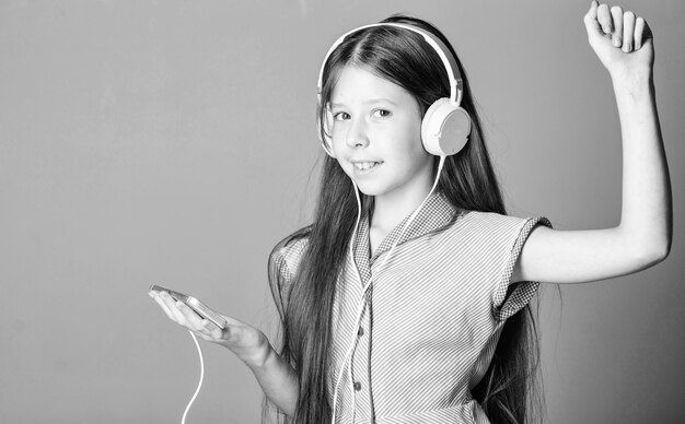 写真 音楽を聴く女の子 モダンなヘッドフォン ガジェット 完璧な音 楽しむ 無料で聴く 音楽コンセプトを楽しむ 音楽アプリ オーディオブック 教育的なコンテンツ オーディオレッスンで英語を勉強する