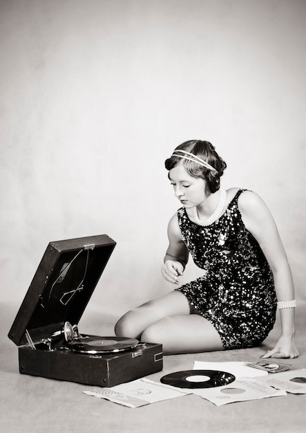 Girl listening to gramophone records. Vintage