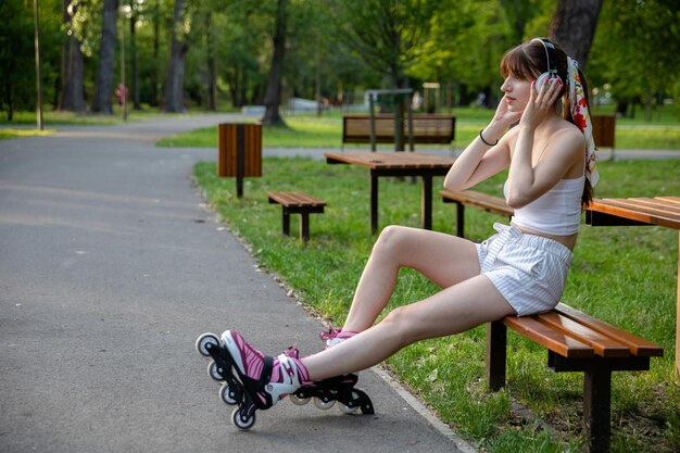 公園でヘッドフォンで音楽を聴いている女の子