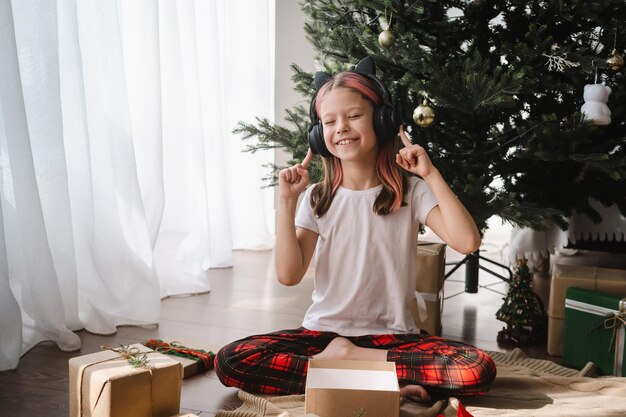 사진 집 에서 크리스마스 를 축하 하는 동안 선물 을 풀면서 음악 을 듣는 소녀