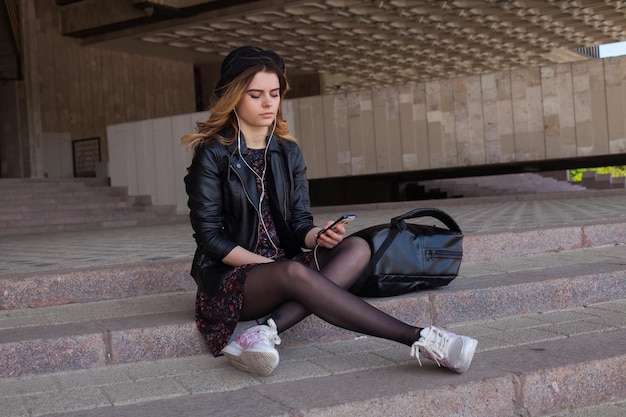 Girl listening to the music with her legs crossed