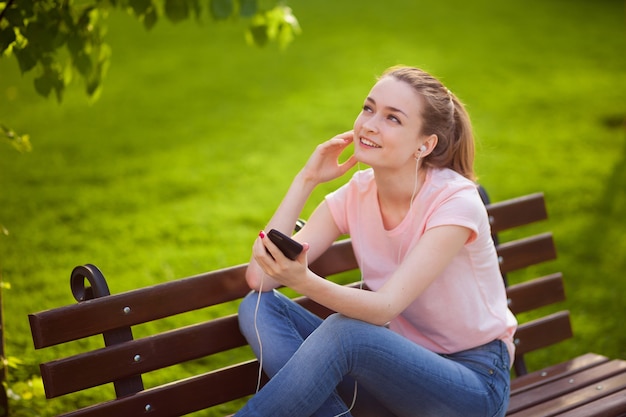 Girl listening to music with mobile phone in Park