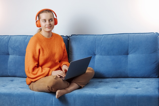 Girl listens to music in headphones at the computer