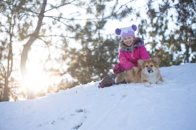 Girl and little cute corgi fluffy puppy at the outdoor. Winter