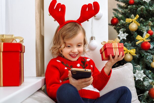 A girl in a little deer costume communicates with relatives on the phone and thanks them for gifts