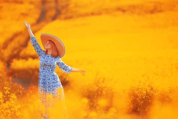 Girl in a long vintage dress hat in a field of flowers, happy summer sunny freedom female