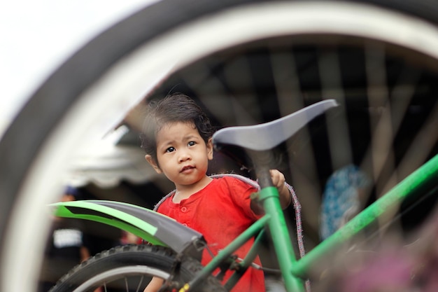 Photo girl looking away seen through bicycle wheel